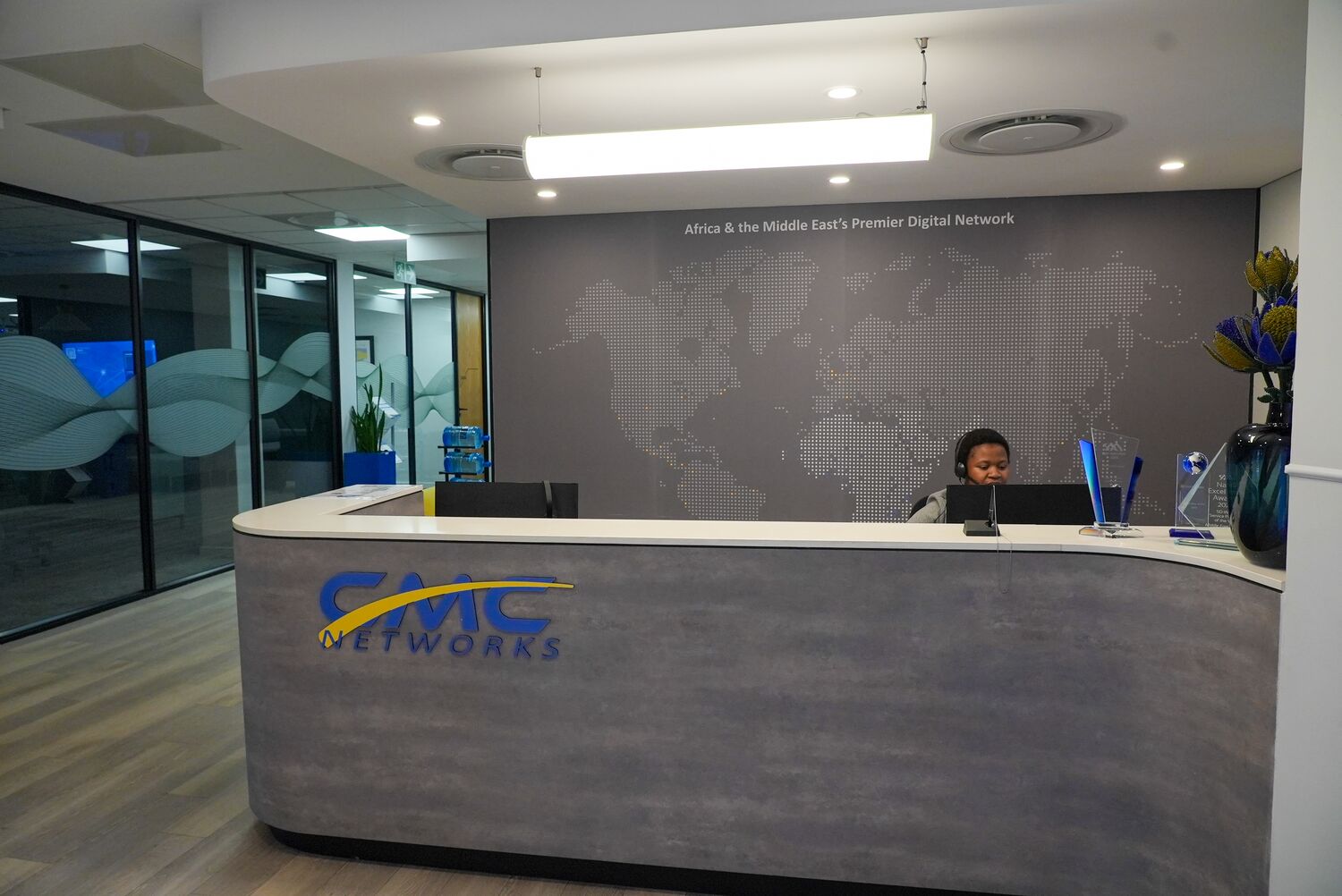 The CMC Networks reception desk with world-map wall