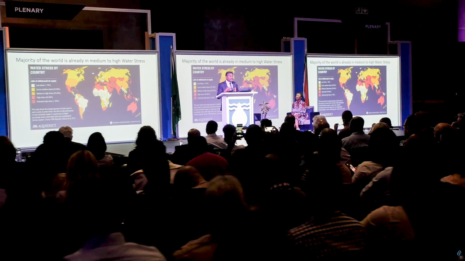 A plenary speaker at the WRC Biennial Symposium with Water Stress by Country maps on the screens