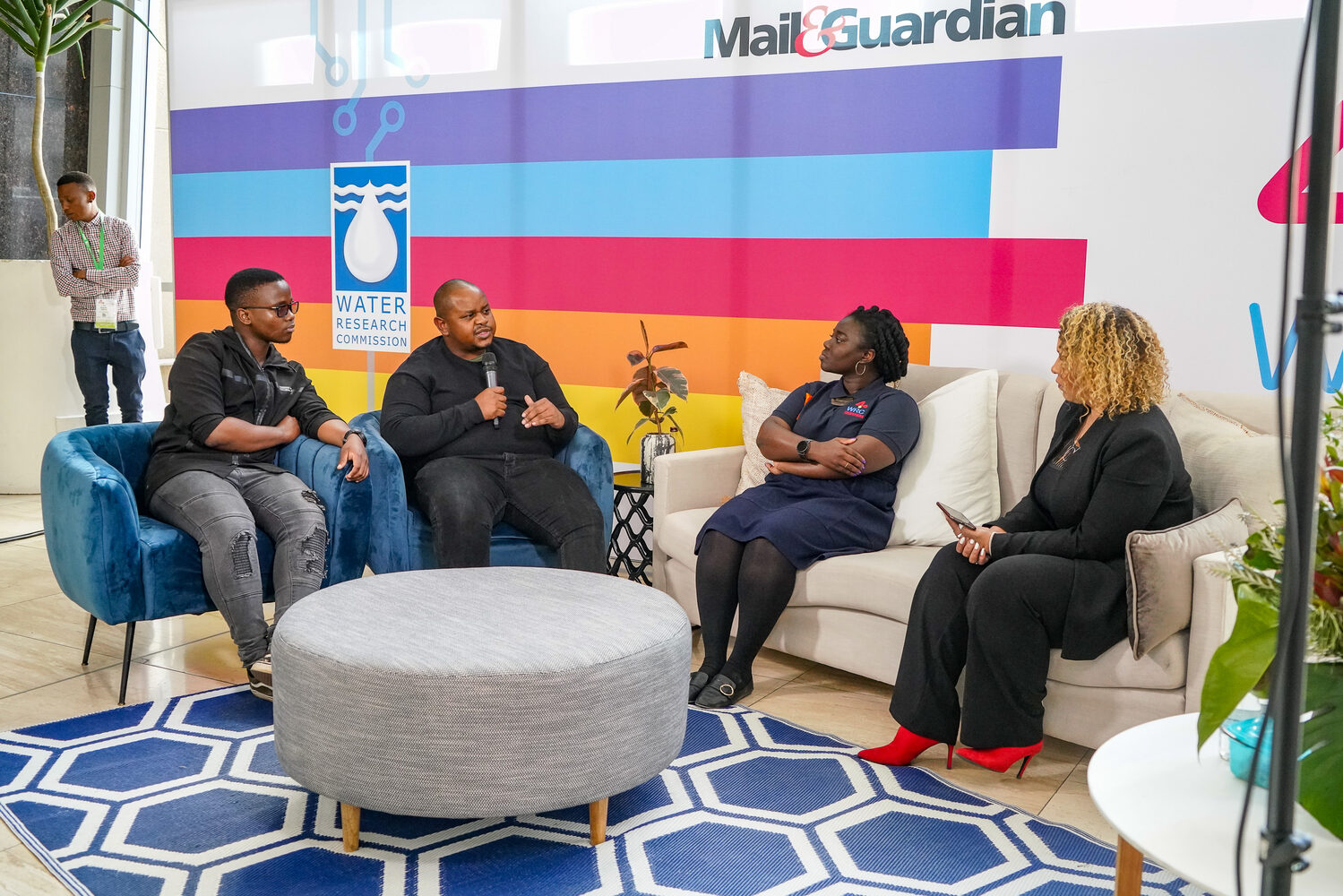 A panel discussion in front of Mail & Guardian and WRC branding