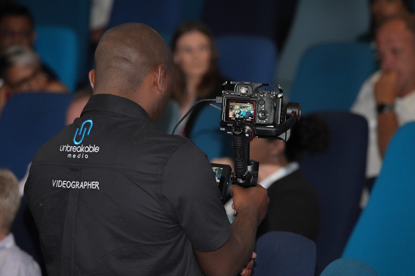 Videographer capturing a session from within the conference audience