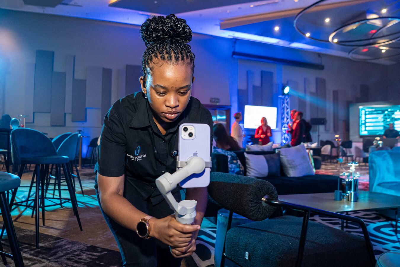 Crew member capturing social media content on a phone gimbal at a live event