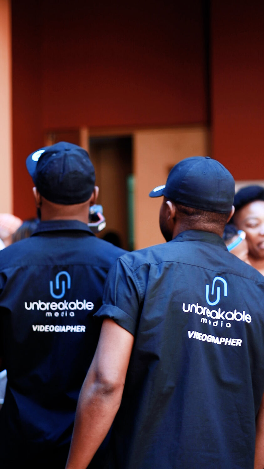 Two Unbreakable Media videographers in branded shirts on assignment