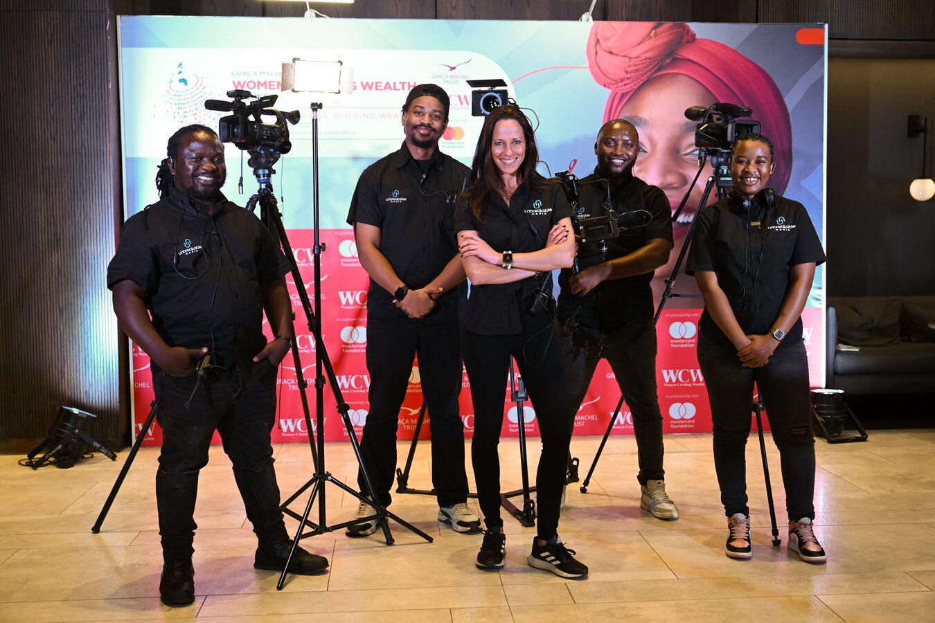 The Unbreakable Media crew lined up in front of an event stage