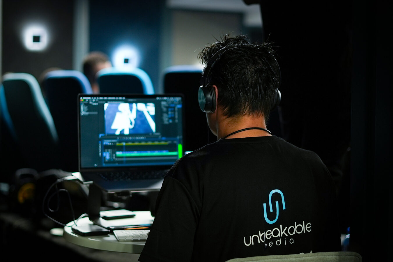 Unbreakable Media onsite editor working at an edit station with headphones