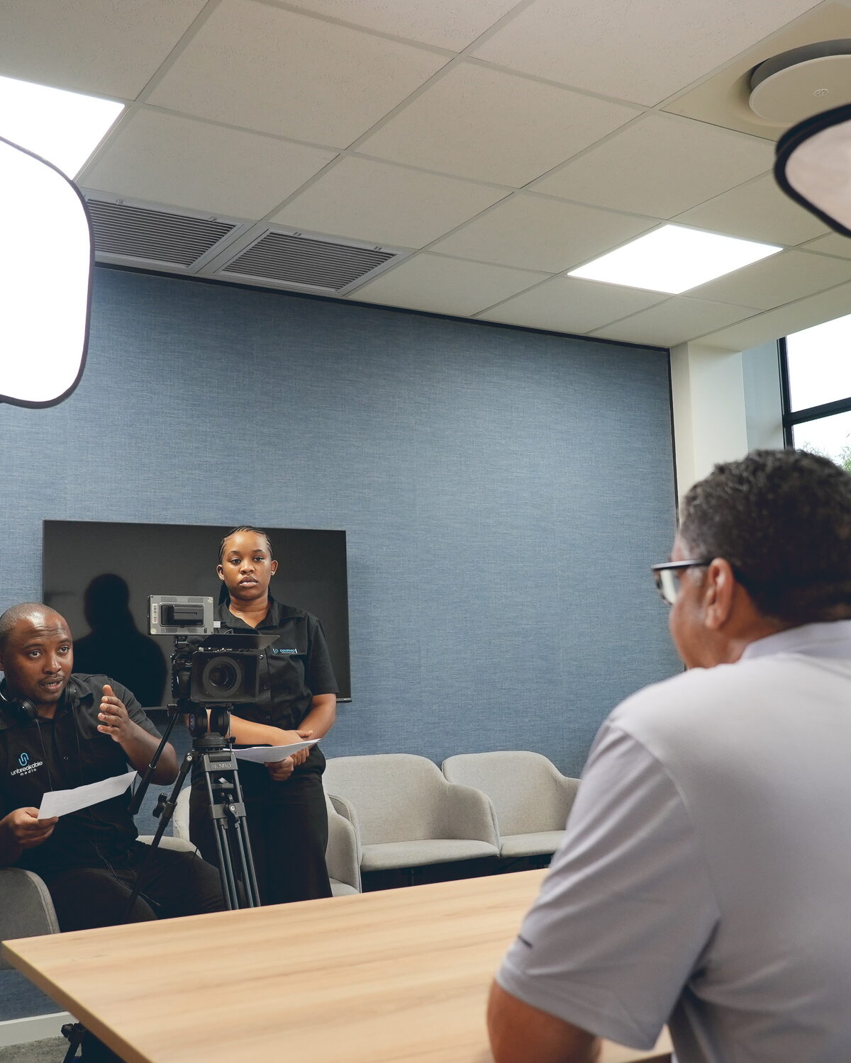 Corporate interview setup with softbox lighting, field monitor, and camera operator
